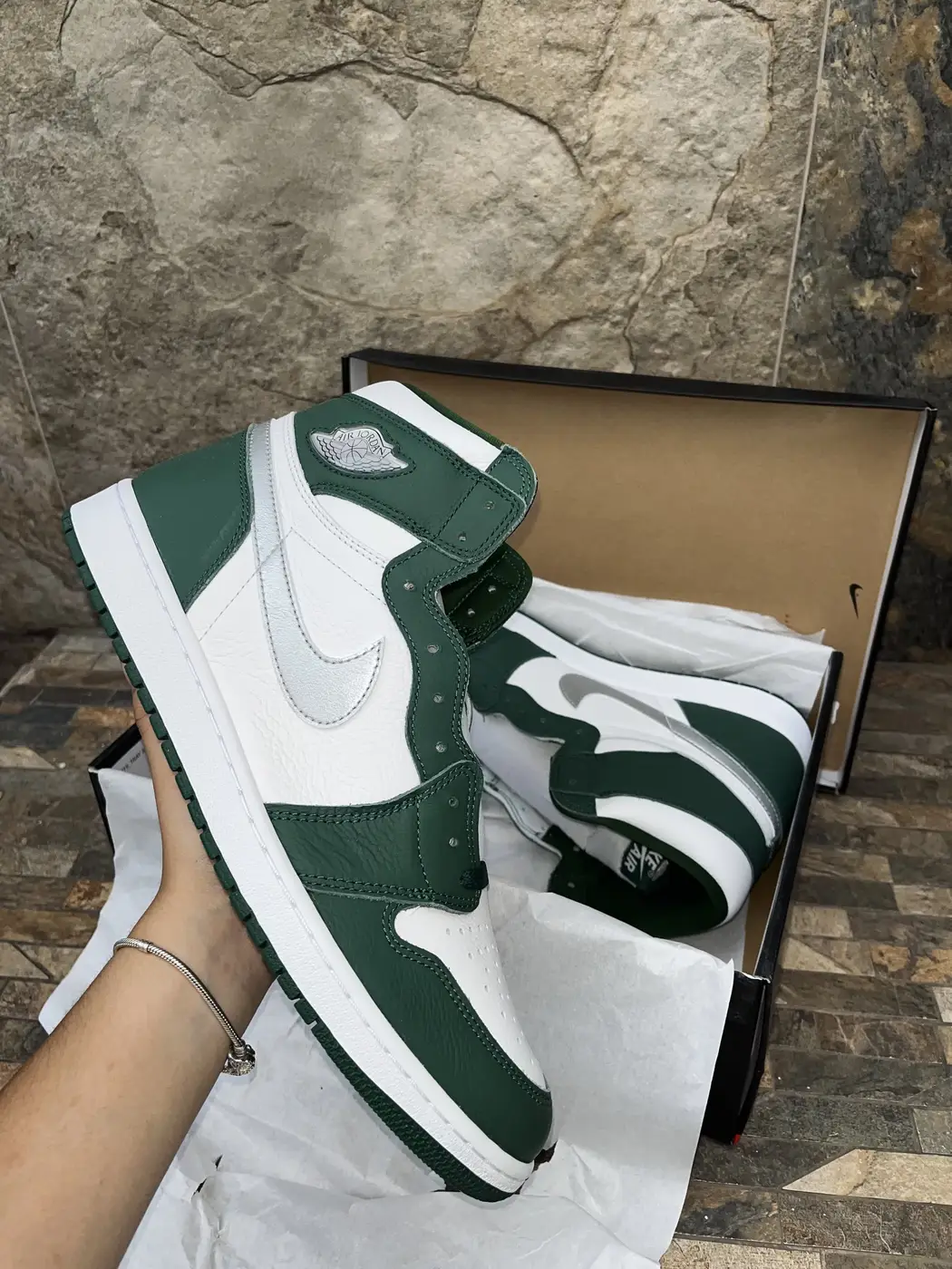 Air Jordan 1 High Verde / Blanco. Lateral exterior sostenido en mano