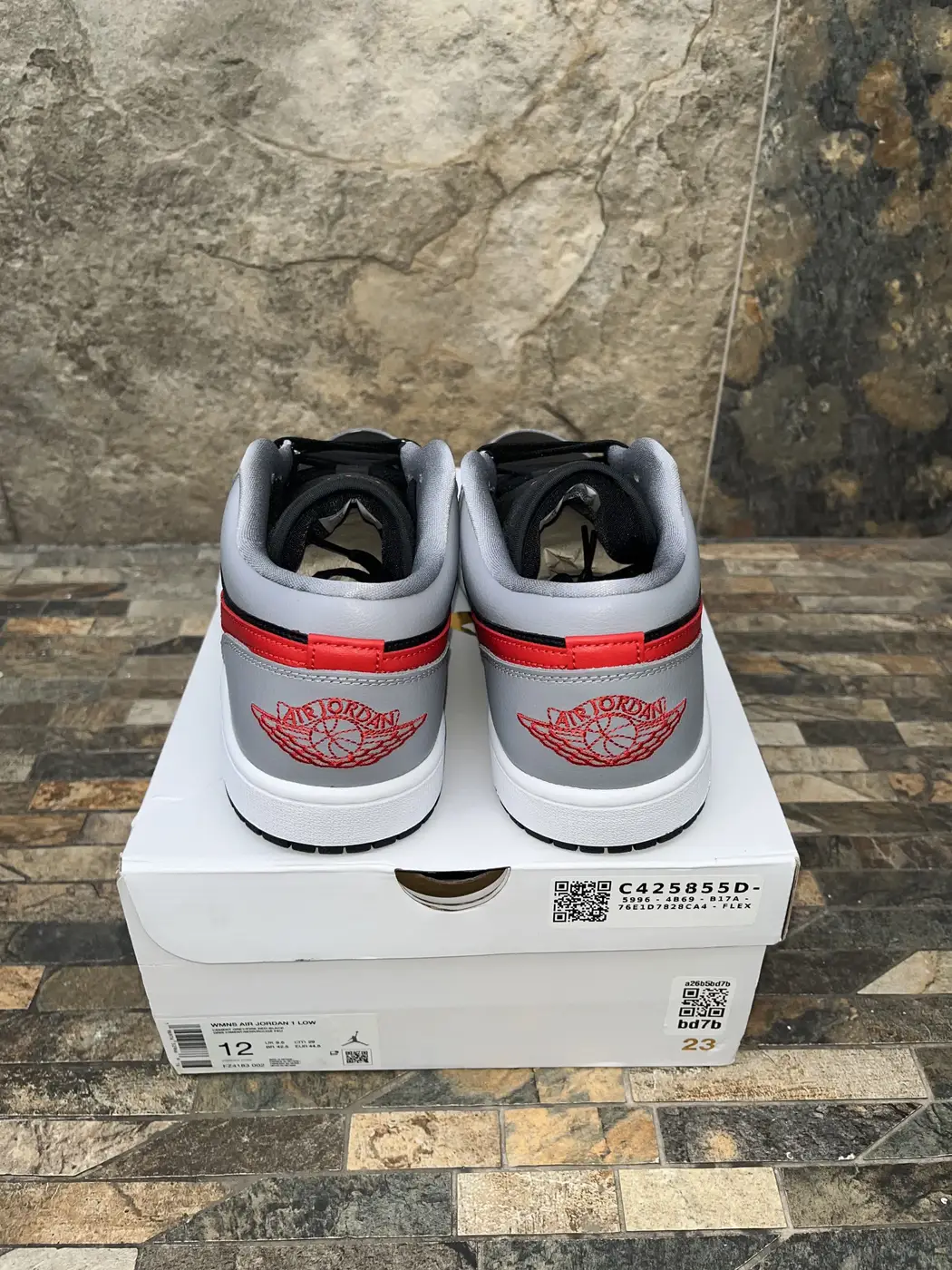 Air Jordan 1 Low Cement Fire Red. Talones con el logo bordado y la etiqueta de la caja